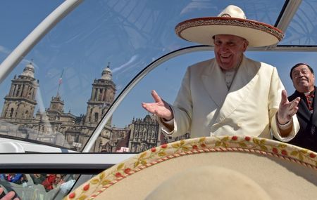 El Papa Francisco hace un gesto mientras usa un sombrero de mariachi que le entregó una persona de la multitud, en la Plaza de la Constitución, en Ciudad de México